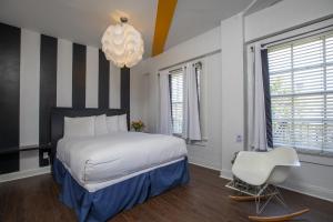 a bedroom with a large bed and a white chair at Edwardian Hotel in San Francisco +17 photos